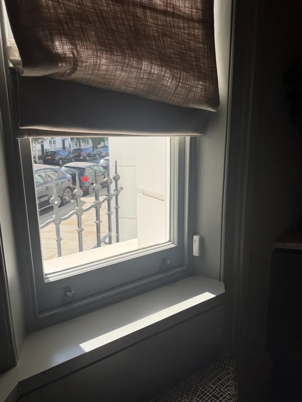 Alarm contact fitted to a window frame below a fabric blind